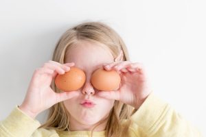 cooking at home with kids | little girl holding two eggs in front of her eyes