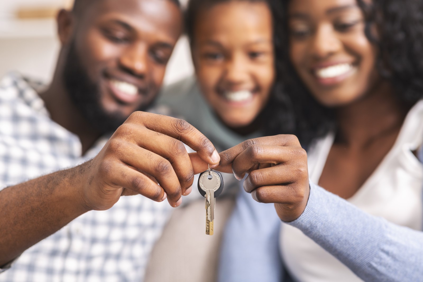 happy young family with keys to new house