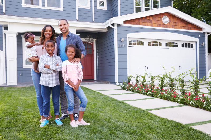 Happy family standing outside their house