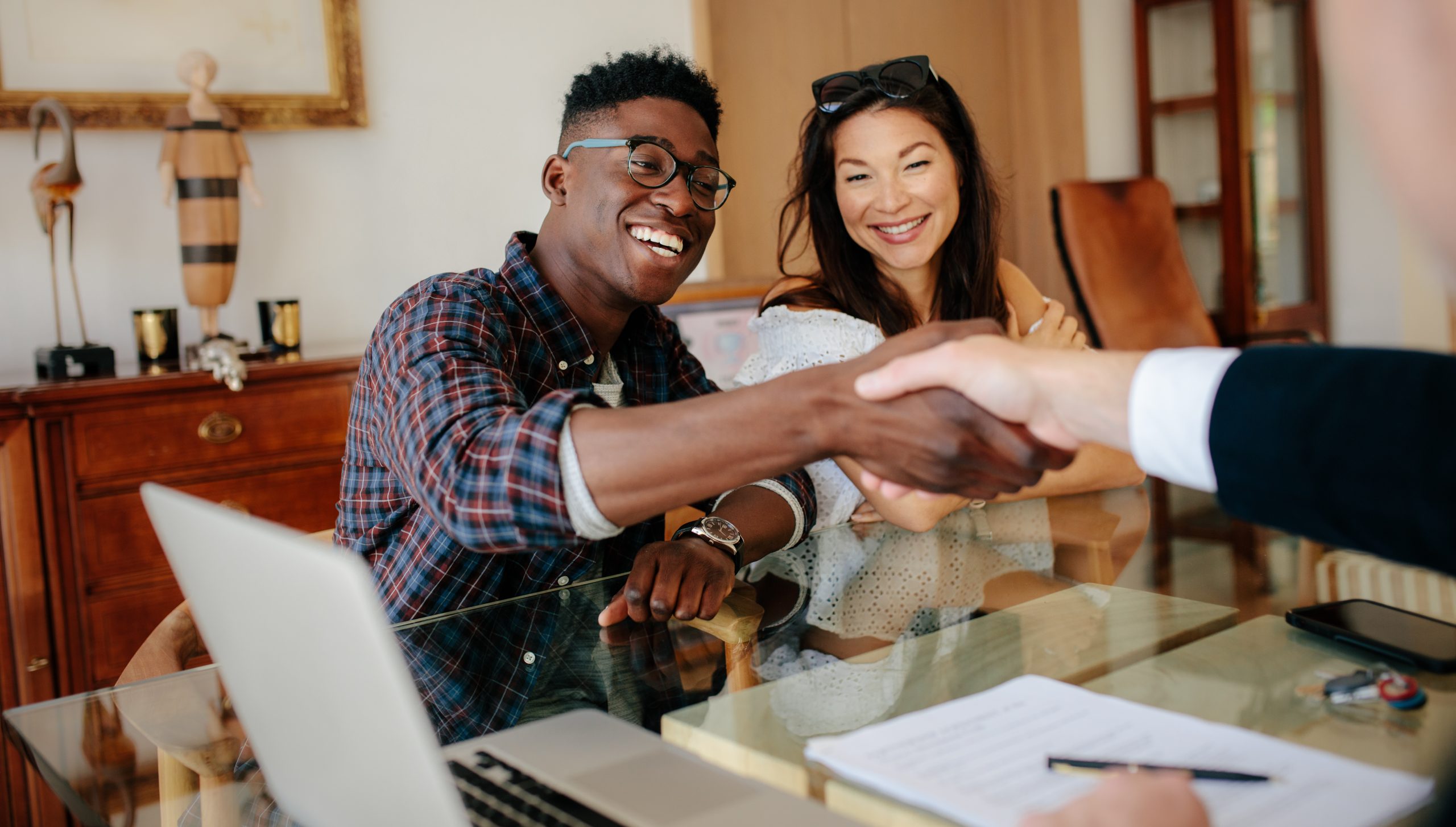 Couple shaking hands with their mortgage officer buying their new home