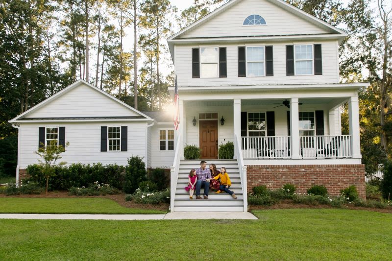 Family sitting on the steps of their front porch