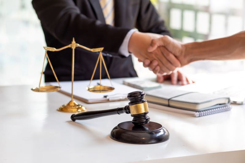 Lawyer shaking hands with their client at their desk